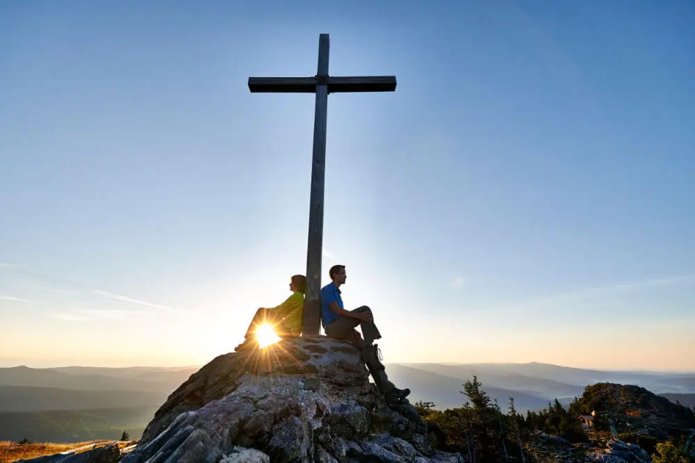 Gipfelkreuz mit Wanderer